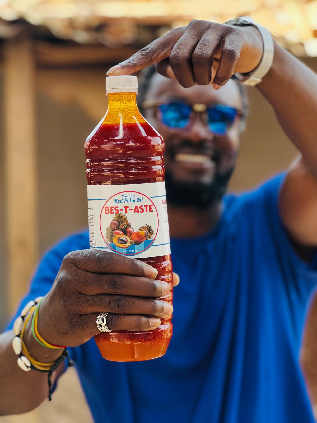 A representative holding a bottle of bes-T-aste Premium Red Palm Oil